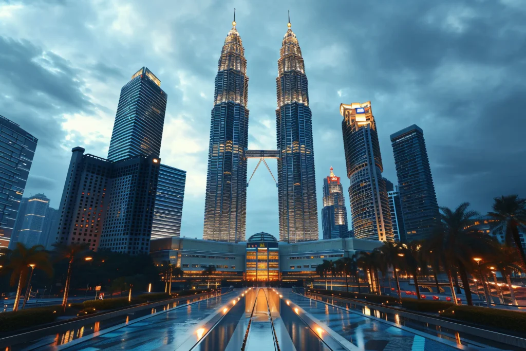 Property investment in Malaysia illustrated by a dramatic evening view of Kuala Lumpur’s skyline, featuring the illuminated Petronas Twin Towers surrounded by modern skyscrapers and city lights.